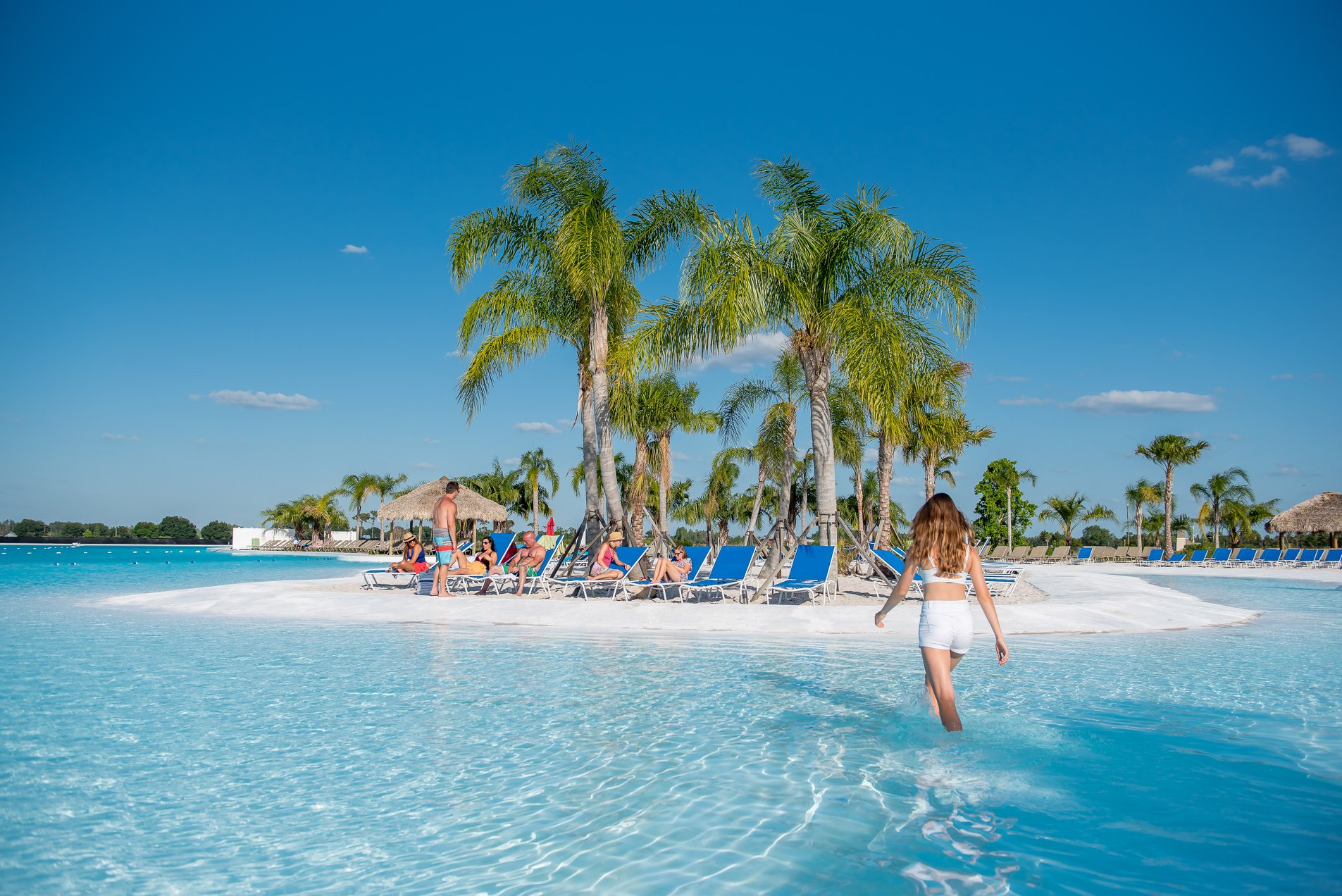 Women walking out of Metro Lagoon onto beach with sun chairs