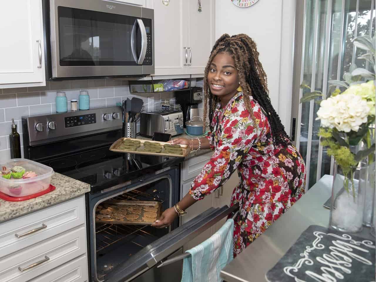 Woman putting cookies in the oven in her kitchen