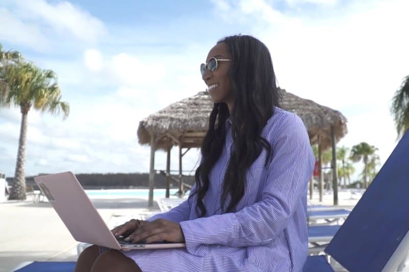 Woman working on a laptop on the pool deck