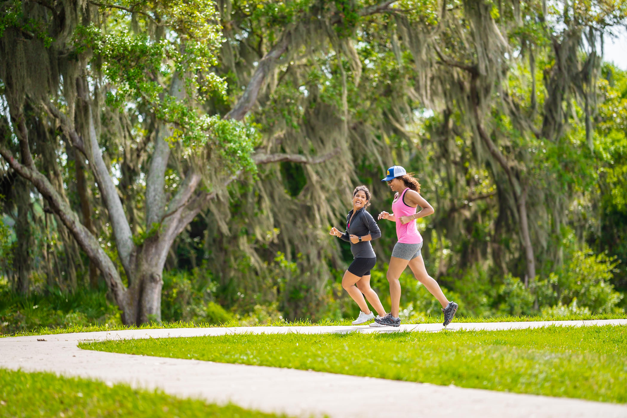 Two women jogging together on a sidewalk in Southshore Bay