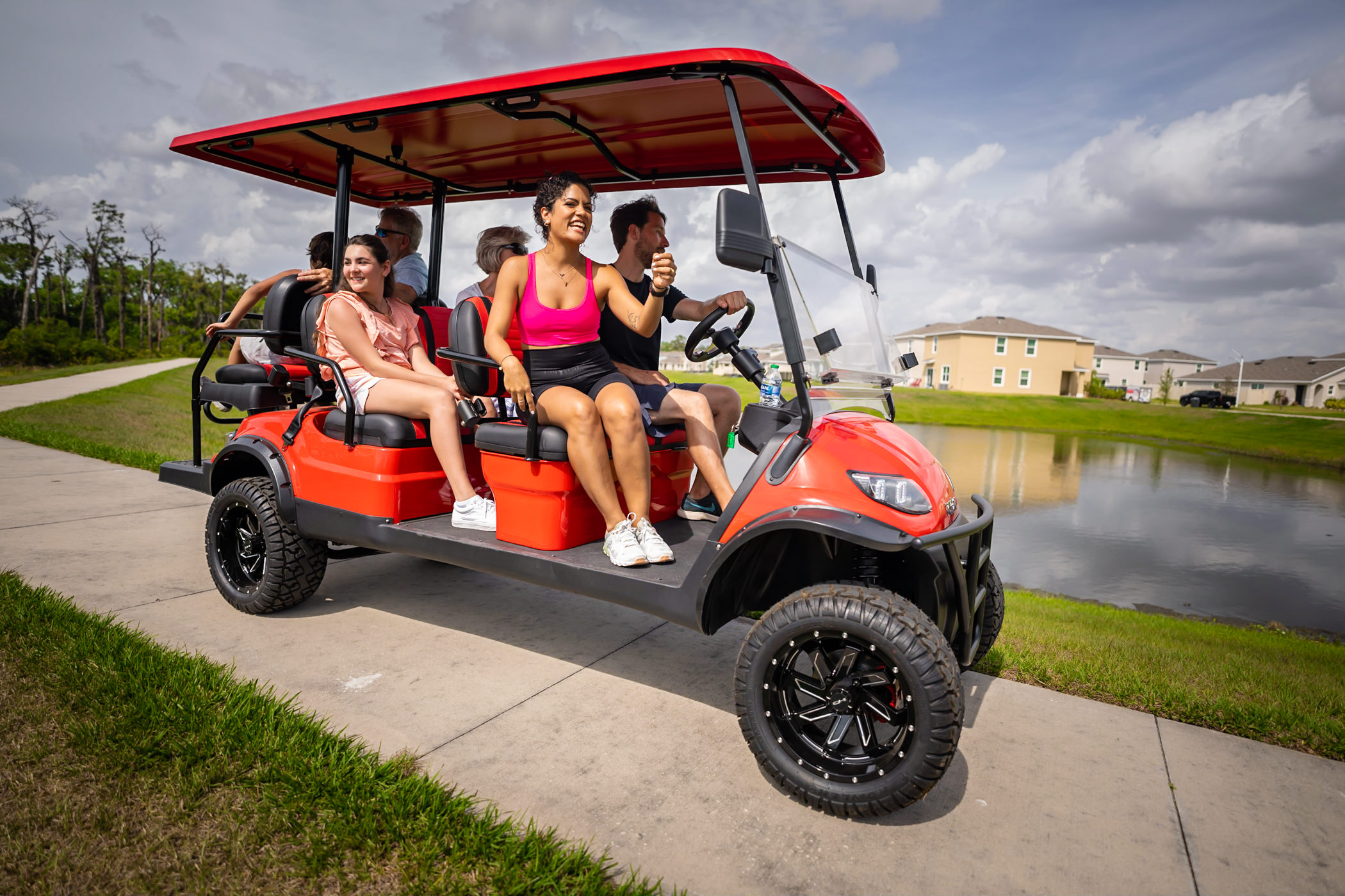 Family riding on a red golf cart