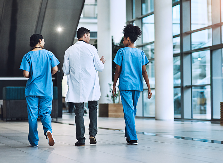 Three doctors walking in hospital hallway